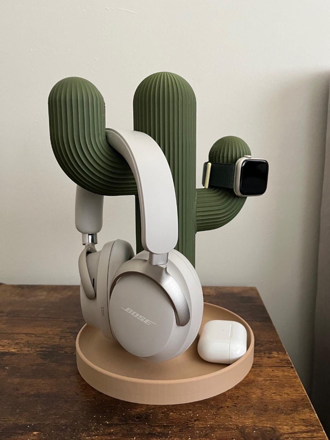 A 3D-printed cactus stand holding headphones, a smart watch and earbuds.