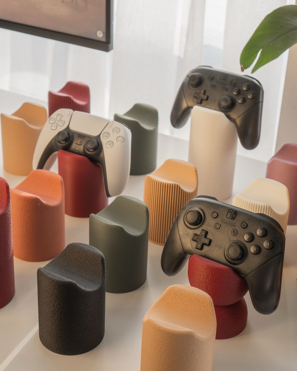 Rows of 3D-printed game controller holders in several colours.