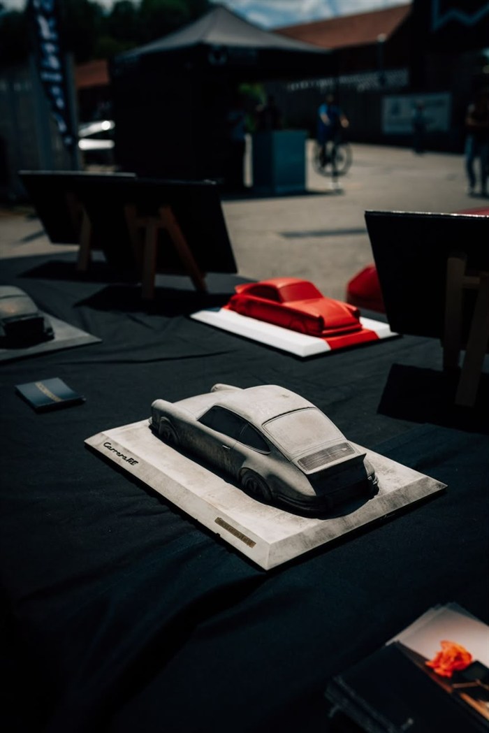 A 3D-printed car model displayed on a plinth at an event.